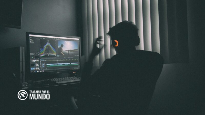 Persona con auriculares editando un vídeo en el ordenador