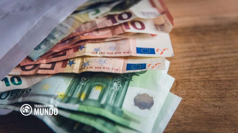 Billetes de euro en abanico sobre una mesa de madera, salario mínimo interprofesional